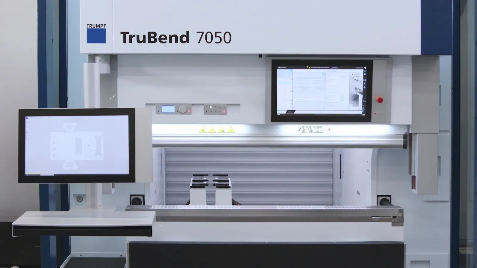 Presse plieuse Trumpf TruBend 7050 : tablier marqué TruBend 7050, pupitre de commande avec écran et table de travail, photo du fabricant.