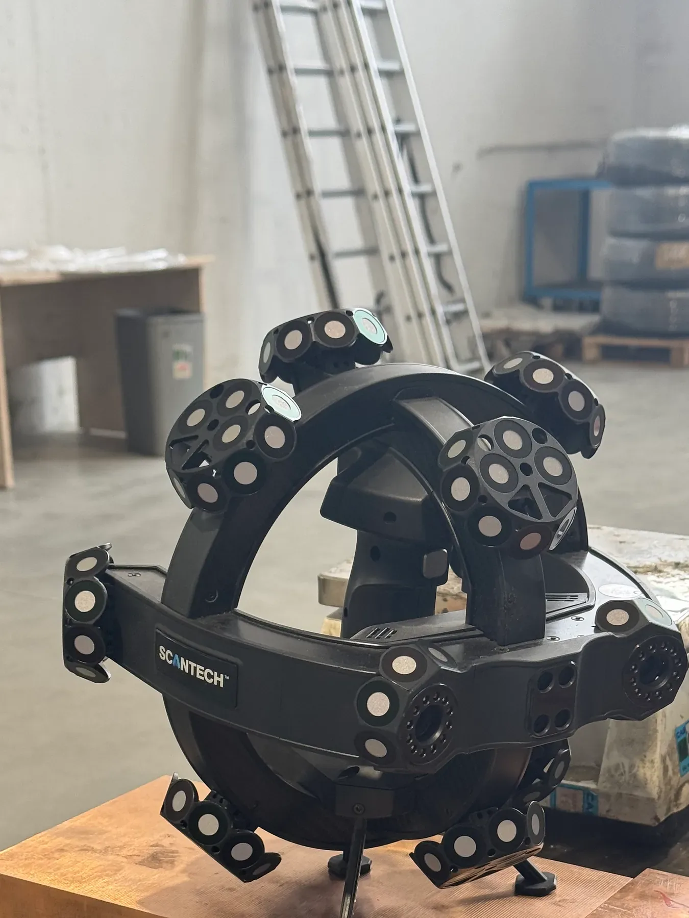 Scanner 3D portatif Scantech NimbleTrack-C Gen2 posé sur des plaques sur une table