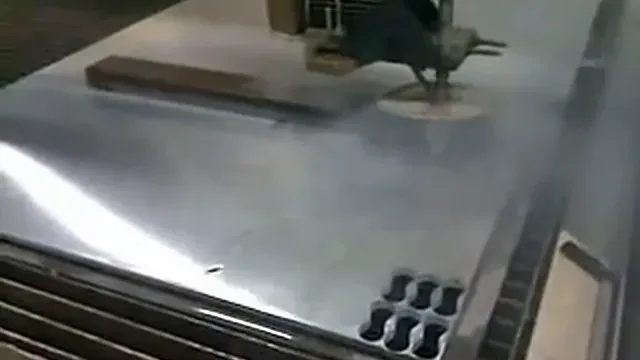Buse de découpe au jet d'eau au-dessus d'une tôle d'aluminium, extrait d'une vidéo de 2009.